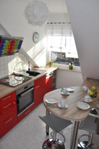 a kitchen with red cabinets and a wooden table at ****Fewo "Alltag...ADE'" in Dippoldiswalde