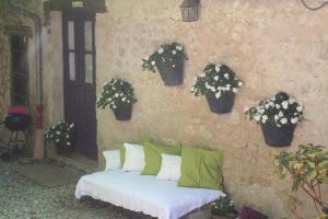 a bed with pillows and plants on a stone wall at Chambre d'hôtes La Romarine in Barnave