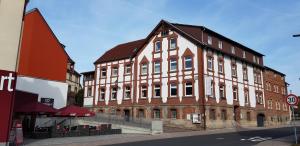 een groot bakstenen gebouw op de hoek van een straat bij Pension zur Sonne 24/7 in Poppenhausen