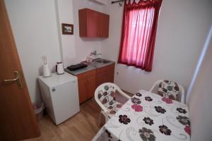 cocina pequeña con mesa y nevera pequeña en Bakal Apartments, en Ohrid