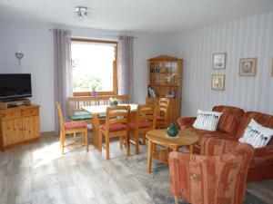 ein Wohnzimmer mit einem Sofa und einem Tisch in der Unterkunft Haus Am Friedrichsbach in Pöhla