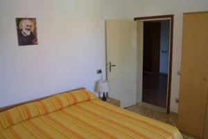 1 dormitorio con 1 cama y puerta al baño en Appartamento a Cecina mare, en Marina di Cecina