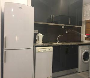 uma cozinha com um frigorífico branco e uma máquina de lavar louça em New Luxury Apartment - Lisbon Center em Lisboa