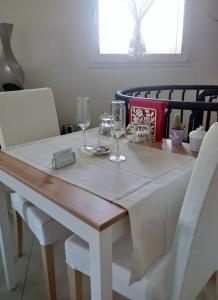 a white table with wine glasses on top of it at La Casetta in Tavullia