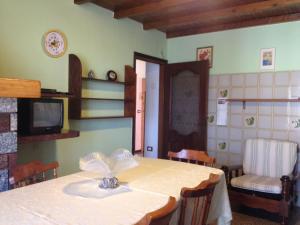 comedor con mesa, sillas y TV en Casa Bondone en Villanuova sul clisi