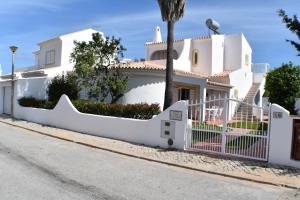 una casa blanca con una valla blanca en Villa Amendoeira-POOL HEATED, en Guia