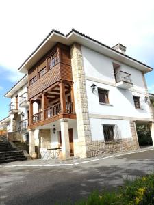 - un grand bâtiment avec un balcon sur le côté dans l'établissement Casona el Palomar, à Muros de Nalón