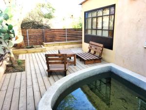 a patio with two benches and a swimming pool at Out of the Wilderness in Midreshet Ben Gurion