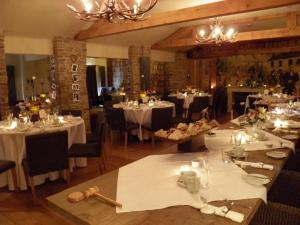 une salle à manger avec des tables, des nappes blanches et des chaises dans l'établissement The Greenman Fownhope Hereford, à Fownhope