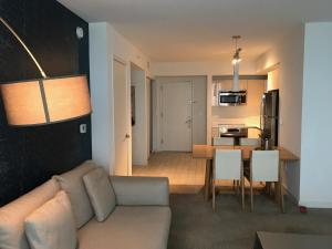 a living room and kitchen with a couch and a table at Beach Walk Resort De Lux Apartment in Hallandale Beach