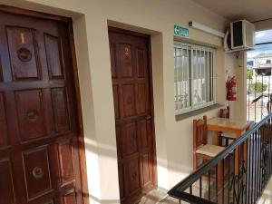 una entrada a una casa con puerta de madera en Apart Hotel DEL LIBERTADOR en Salta