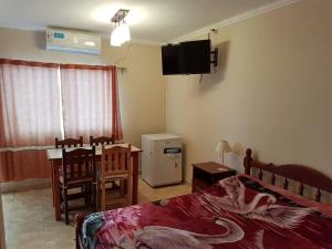 1 dormitorio con 1 cama y TV en la pared en Apart Hotel DEL LIBERTADOR en Salta