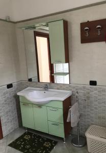 uma casa de banho com um lavatório verde e um espelho em Villa panorama em Montecorvino Pugliano