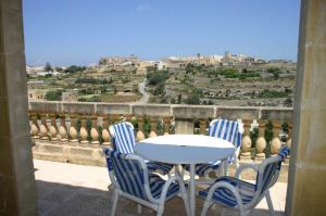 a table and chairs on a balcony with a view at Sylvia' s Millhouse in Kerċem