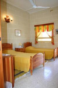a bedroom with two beds and a window at Sylvia' s Millhouse in Kerċem