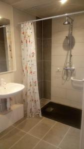 a bathroom with a shower curtain and a sink at Paysannerie des Versanes - Chambre et gîte à la ferme in Tour-de-Faure