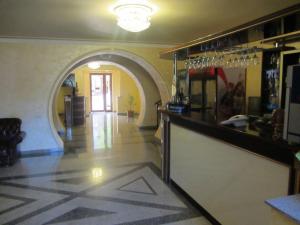 a bar in a restaurant with a hallway with an archway at Primer Hotel in Yerevan