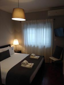 ein Schlafzimmer mit einem Bett mit zwei Handtüchern darauf in der Unterkunft ML Apartments Almirante in Porto