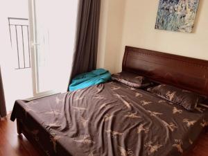 een bed met een bruin dekbed in een slaapkamer bij SHP Plaza 12 Lach Tray Hai Phong in Hai Phong