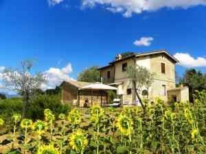 a house in the middle of a field of sunflowers at Appartamenti Verde Collina Umbra in Bevagna
