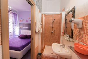 a bathroom with a sink and a shower with a bed at Roma Gianicolense in Rome