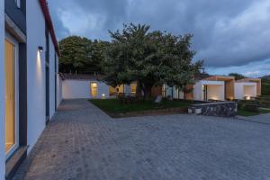 a courtyard of a house with a tree and a building at Quinta de Santa Clara in Ponta Delgada