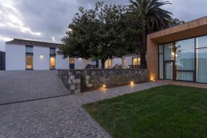 a house with a stone wall and a yard at Quinta de Santa Clara in Ponta Delgada