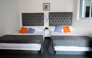 - deux lits assis l'un à côté de l'autre dans une pièce dans l'établissement Hotel Grand H&R, à Villeta