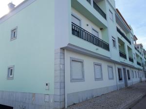 a white building with balconies on the side of it at Cabanas Family Apartment in Cabanas de Tavira