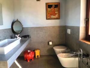 a bathroom with a sink and a pink pig in it at Appartamenti Verde Collina Umbra in Bevagna