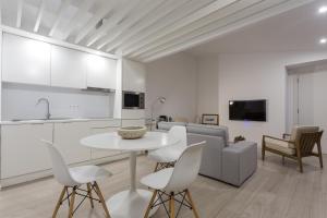 a kitchen and a living room with a table and chairs at Quinta de Santa Clara in Ponta Delgada
