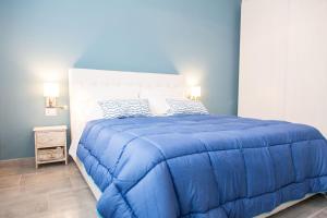 Dormitorio azul con cama grande y edredón azul en Gru House, en Grugliasco