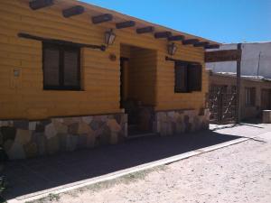 ein gelbes Gebäude mit einem Schild an der Seite in der Unterkunft Hosteria Las Tinajas in Tilcara