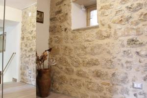 a room with a stone wall and a vase with flowers at Al Borghetto in Piazza Armerina +91 photos