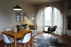 sala de estar con mesa, sillas y sofá en Antico Casale Rodilosso, en Montaione