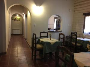 a restaurant with two tables and chairs and a hallway at Hosteria Las Tinajas in Tilcara