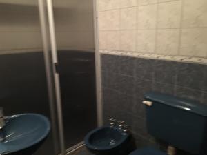 uma casa de banho com um WC azul e um lavatório. em Hosteria Las Tinajas em Tilcara