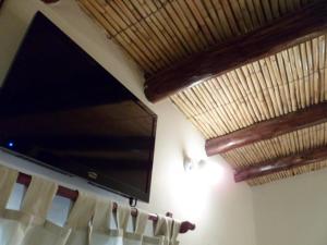a flat screen tv hanging on a wall with a curtain at Hosteria Las Tinajas in Tilcara