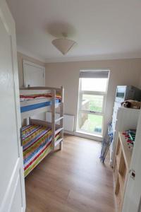 a room with two bunk beds and a window at Cloughey holiday lodge in Kirkistown