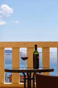 a bottle of wine and a glass on a table on a balcony at Apartment Punta in Seget Vranjica