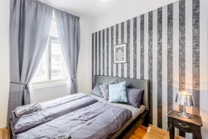 a bedroom with a large bed and a large window at Top Wenceslas Square Apartment in Prague