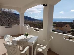a white table and chairs on a balcony with a view at Apartments Ana Baska in Baška
