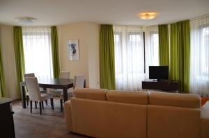 a living room with a couch and a dining room table at Guest House Laudis in Bansko