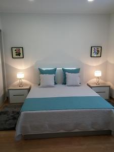 フルナスにあるCasa da Água Quente 2のベッドルーム1室(青い大型ベッド1台、ナイトスタンド2台付)