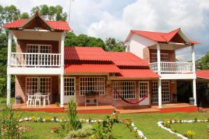 a house with a red roof and a yard at Hotel finca Carmentea in Restrepo