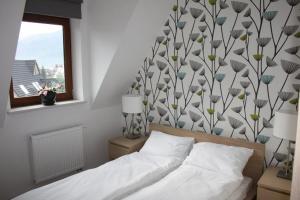 1 dormitorio con cama y pared con estampado de flores en Krokusowa Polana, en Kościelisko