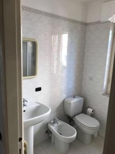 een witte badkamer met een toilet en een wastafel bij Romantica Bocca di Magra in Bocca di Magra