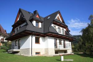 a house with a gambrel roof on top of it at Krokusowa Polana in Kościelisko