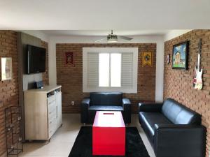 uma sala de estar com dois sofás de couro e uma televisão em Casa de Campo às margens do lago de furnas em Boa Esperança