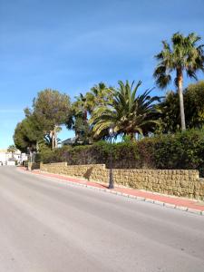 una strada vuota con palme e un muro di pietra di Duquesa Suites. Manilva a San Luis de Sabinillas